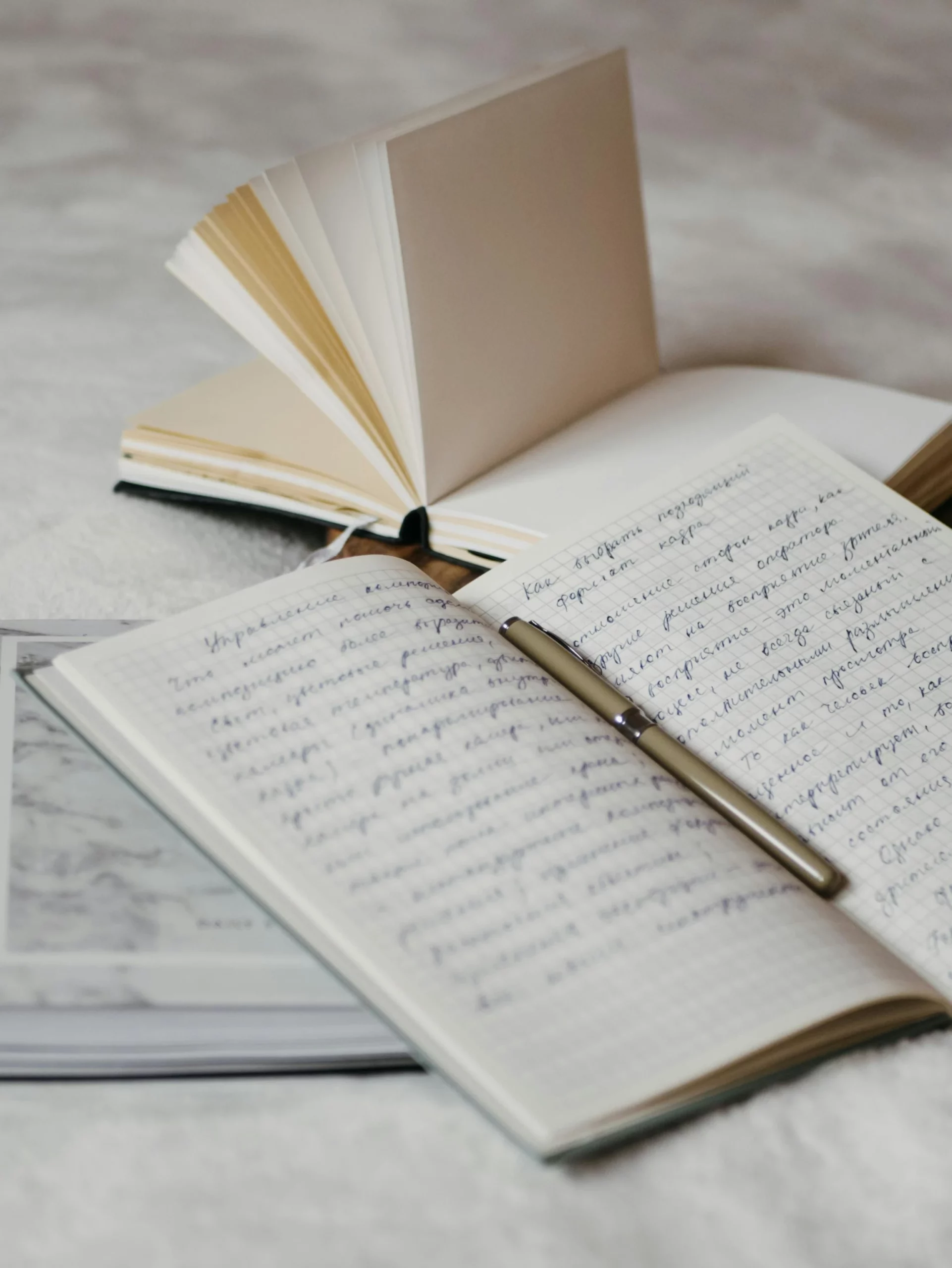 Carnet rempli d'écriture avec un stylo au centre
